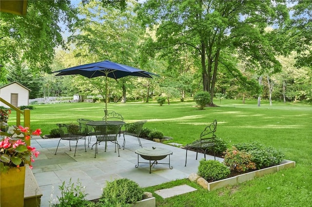 view of community featuring a lawn and a patio area