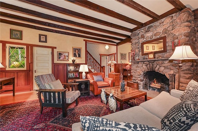 living room featuring hardwood / wood-style flooring, a fireplace, and beamed ceiling