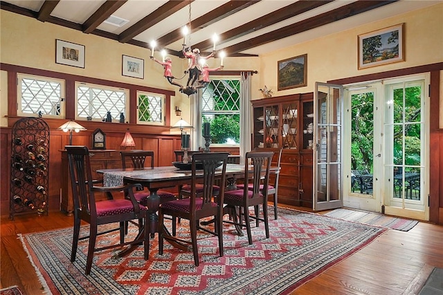 dining room with an inviting chandelier, beam ceiling, and light hardwood / wood-style floors