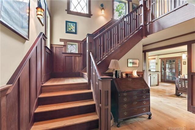 stairway with hardwood / wood-style flooring and a high ceiling