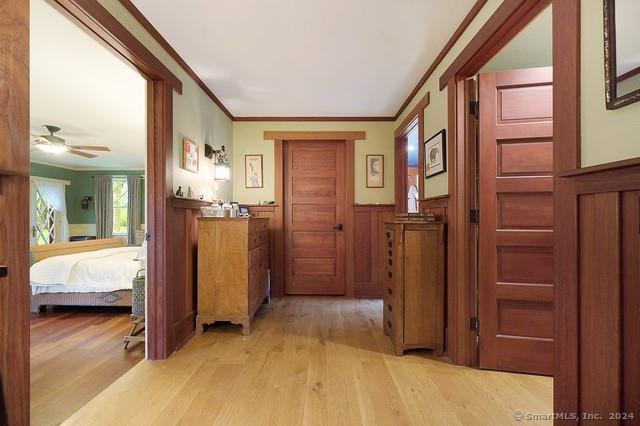 hall with crown molding and light hardwood / wood-style flooring