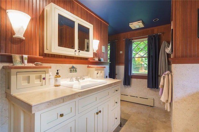 bathroom featuring vanity, a baseboard radiator, and wood walls