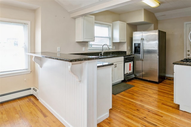 kitchen with white cabinets, sink, stainless steel fridge, and kitchen peninsula