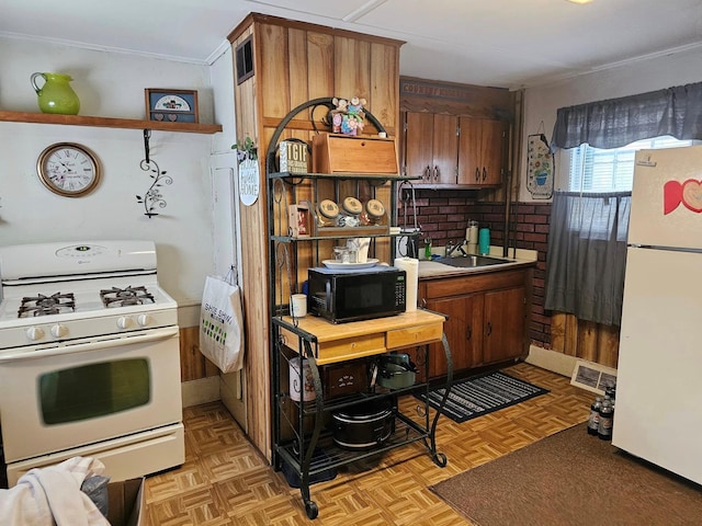 kitchen featuring crown molding, sink, white appliances, and light parquet floors