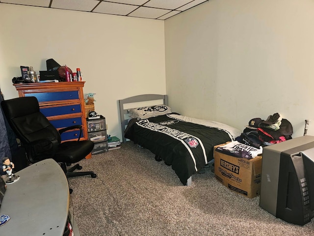 carpeted bedroom featuring a drop ceiling