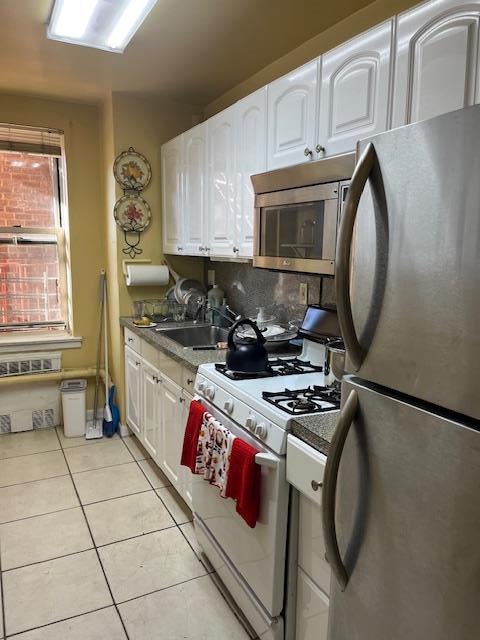 kitchen featuring white cabinetry, sink, stainless steel appliances, and light tile patterned flooring