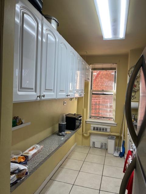 kitchen featuring light tile patterned floors and white cabinets