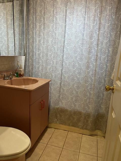 bathroom featuring vanity, tile patterned floors, and toilet