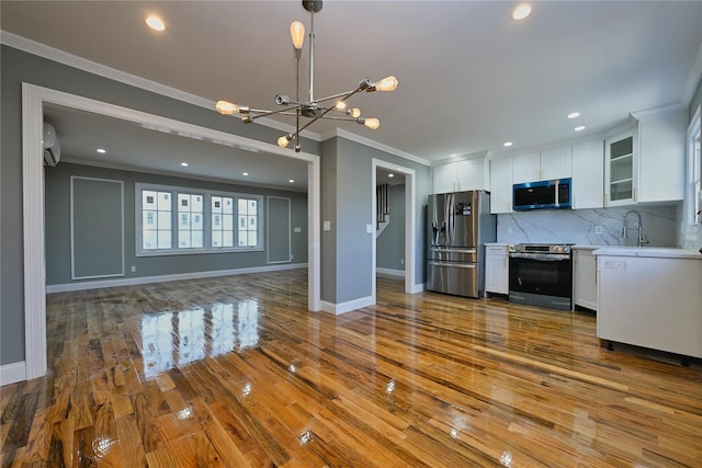 kitchen with white cabinetry, crown molding, tasteful backsplash, and appliances with stainless steel finishes