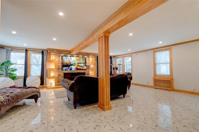 living room featuring crown molding, plenty of natural light, radiator heating unit, and ornate columns