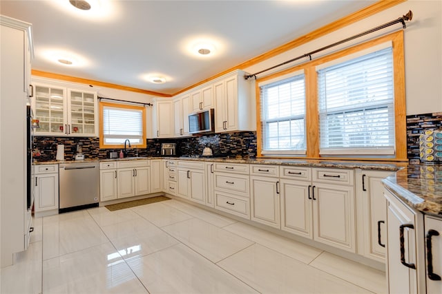 kitchen with crown molding, stainless steel dishwasher, decorative backsplash, and stone counters