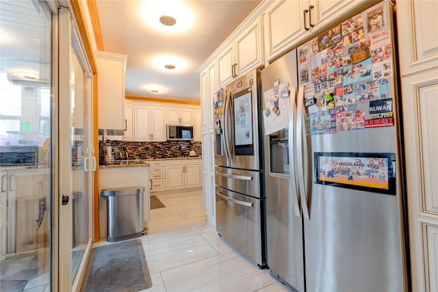 kitchen with tasteful backsplash, light tile patterned floors, stainless steel fridge, and dark stone countertops