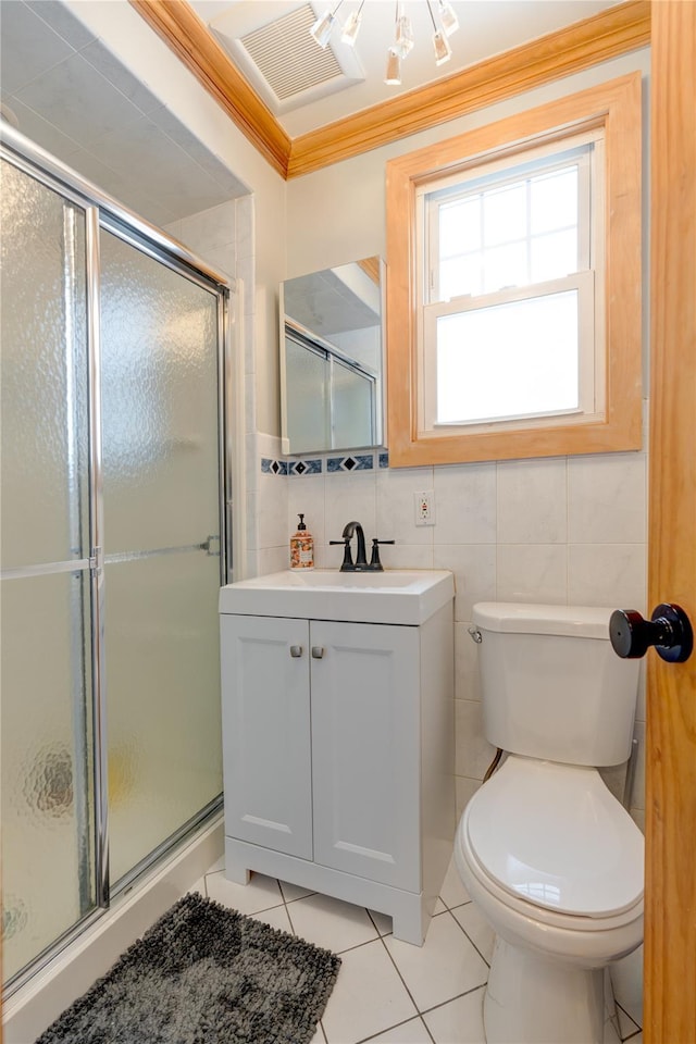 bathroom with tile walls, vanity, a shower with shower door, tile patterned floors, and toilet