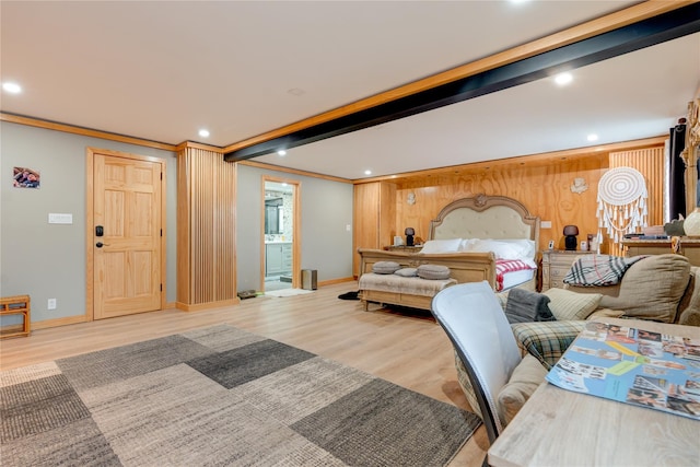 bedroom featuring crown molding, beam ceiling, ensuite bathroom, and light wood-type flooring