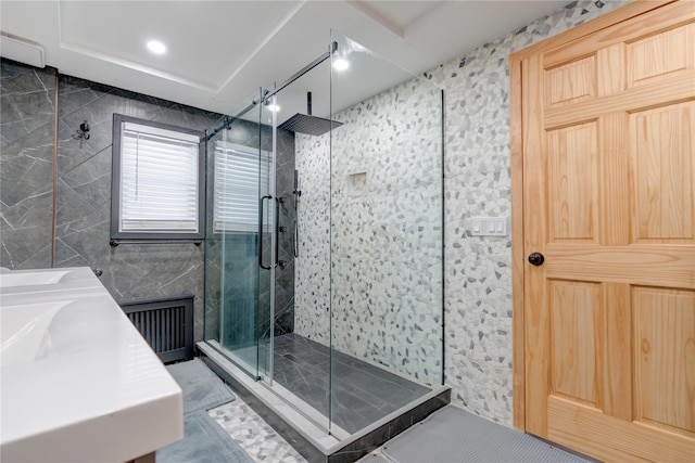 bathroom featuring radiator heating unit, a shower with shower door, tile walls, and vanity