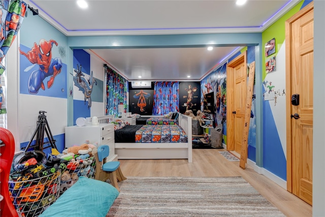 bedroom featuring ornamental molding and light hardwood / wood-style floors