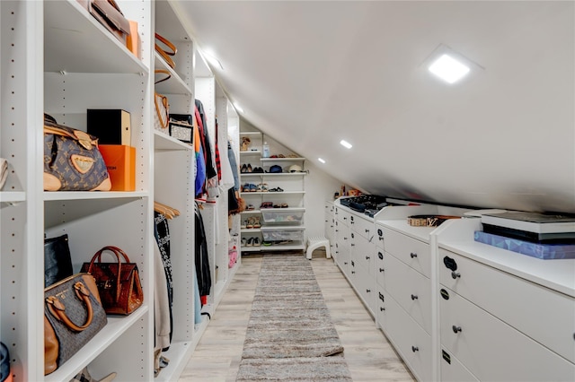 walk in closet featuring lofted ceiling and light hardwood / wood-style floors