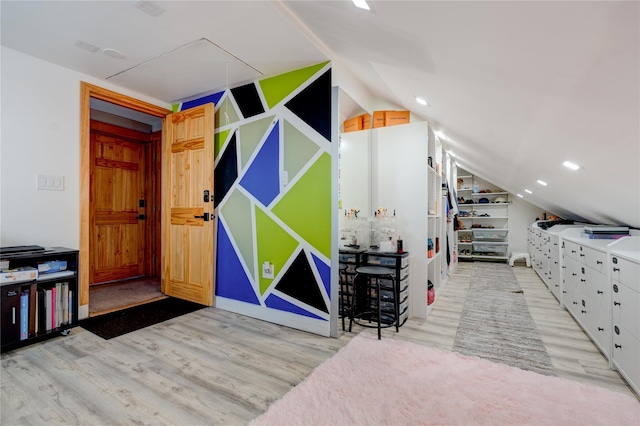 bedroom with vaulted ceiling and light wood-type flooring