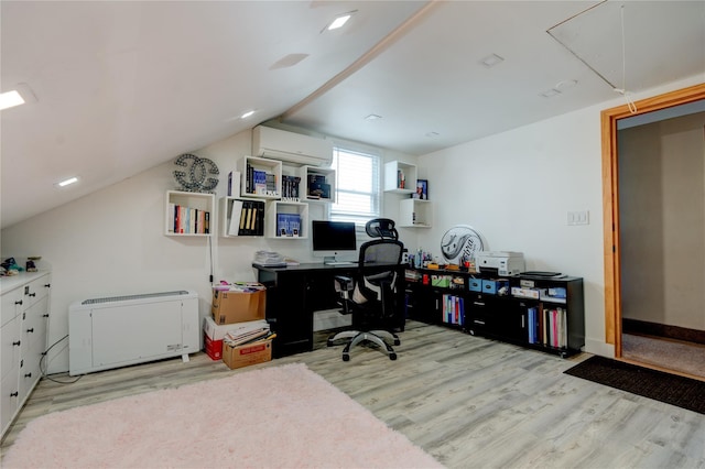 office space with vaulted ceiling, a wall mounted air conditioner, and light hardwood / wood-style floors