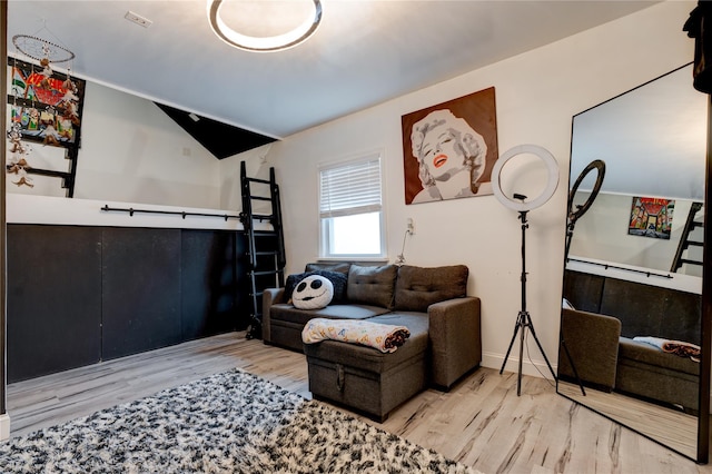 living room featuring vaulted ceiling and light hardwood / wood-style floors