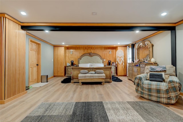 bedroom with ornamental molding, beamed ceiling, and light wood-type flooring