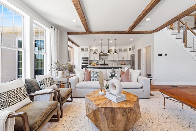 living area featuring baseboards, stairway, light wood-type flooring, beam ceiling, and recessed lighting