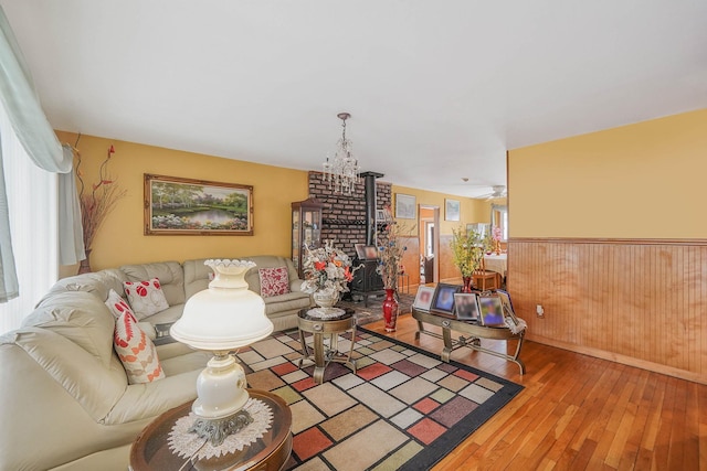 living room with a wood stove, hardwood / wood-style floors, and wooden walls