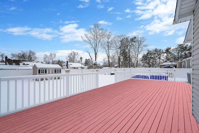 wooden terrace with a pool and a storage unit