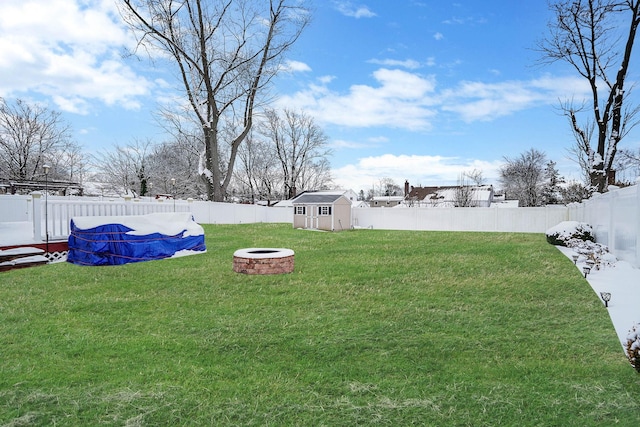 view of yard featuring a fire pit and a storage unit