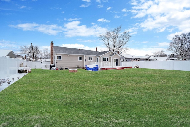 back of house featuring a yard and an outdoor fire pit