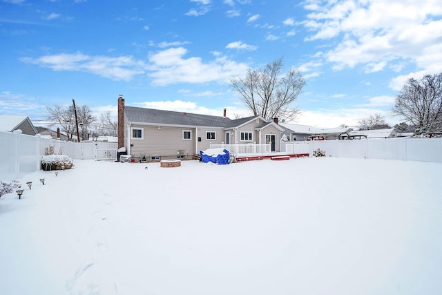 snow covered property with a deck and an outdoor fire pit