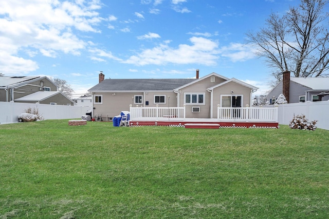 back of house with a wooden deck and a lawn