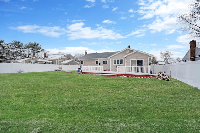 back of property with a deck and a lawn