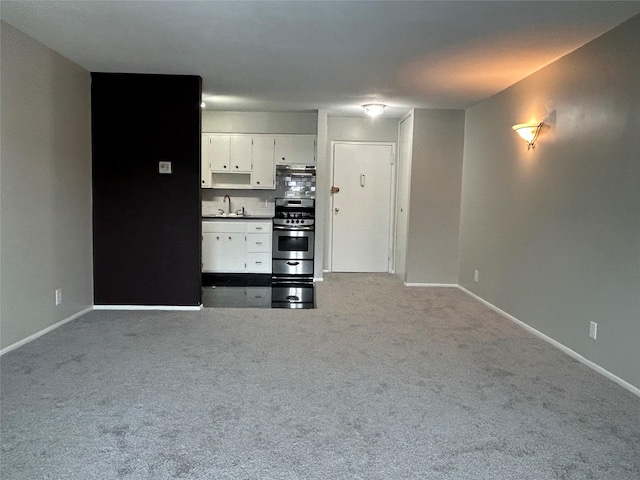 unfurnished living room with sink and light carpet