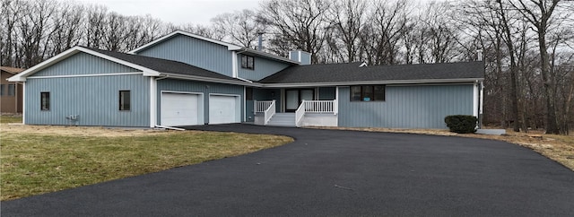 front facade with a garage, central AC, a front yard, and covered porch