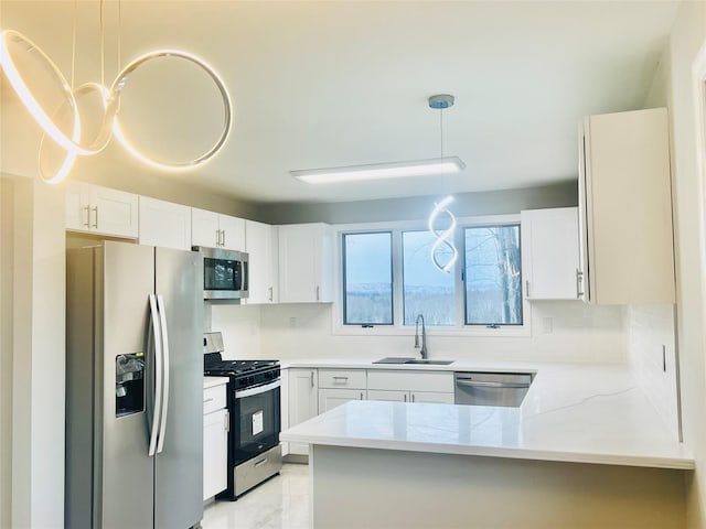 kitchen with appliances with stainless steel finishes, decorative light fixtures, white cabinetry, sink, and kitchen peninsula