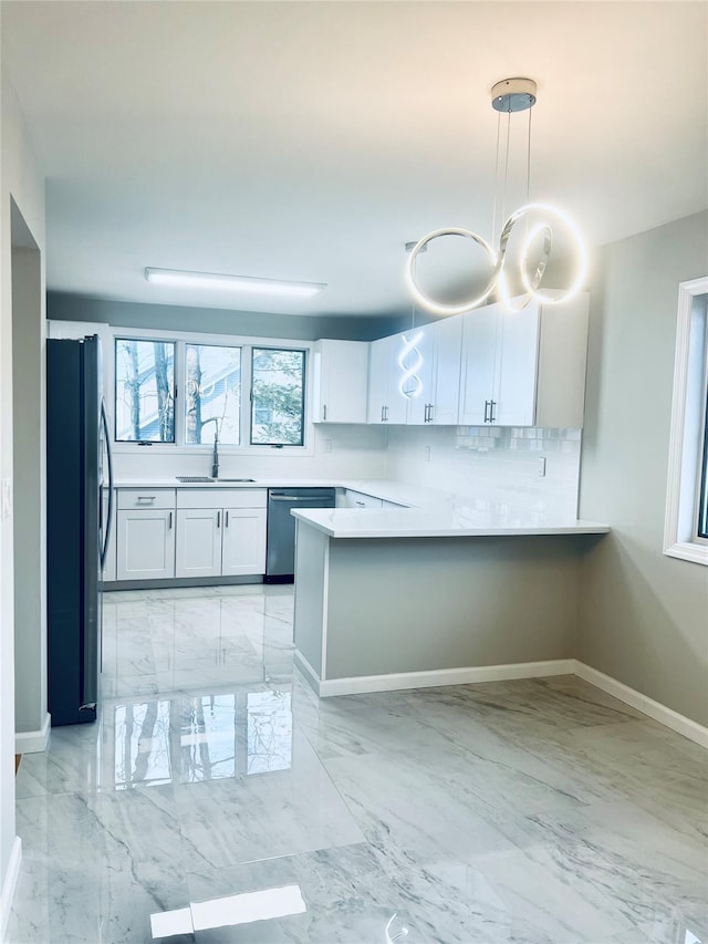 kitchen with stainless steel appliances, kitchen peninsula, hanging light fixtures, and white cabinets