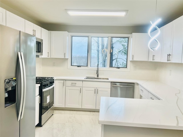 kitchen featuring sink, appliances with stainless steel finishes, white cabinetry, tasteful backsplash, and kitchen peninsula