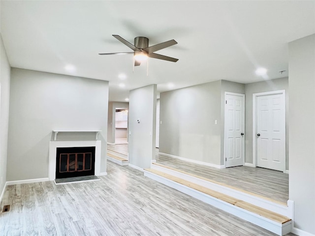 unfurnished living room with ceiling fan and light hardwood / wood-style flooring