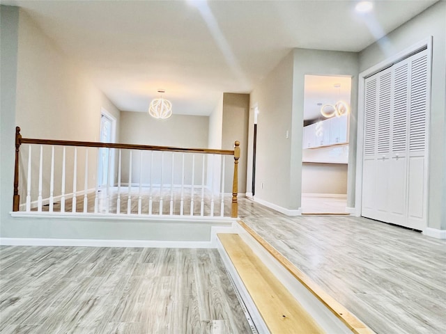 corridor featuring a notable chandelier and hardwood / wood-style flooring