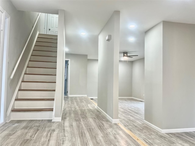 stairway featuring wood-type flooring and ceiling fan