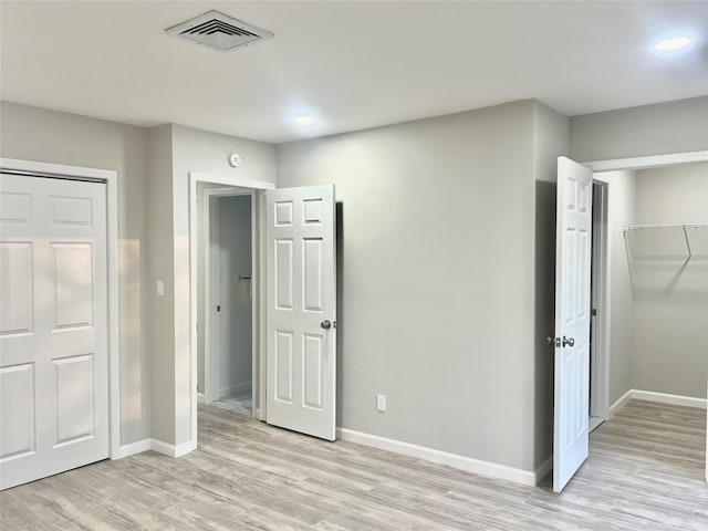 unfurnished bedroom featuring a closet and light hardwood / wood-style flooring