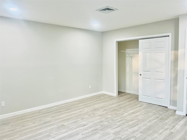 unfurnished bedroom featuring light hardwood / wood-style floors and a closet