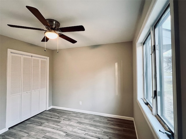 unfurnished bedroom with ceiling fan, wood-type flooring, and a closet