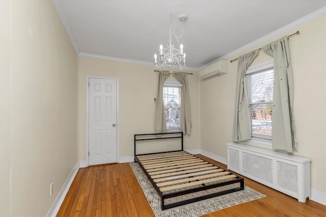 interior space featuring radiator, crown molding, an inviting chandelier, a wall mounted AC, and light wood-type flooring