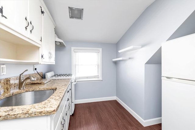 kitchen featuring sink, light stone counters, dark hardwood / wood-style flooring, white appliances, and white cabinets