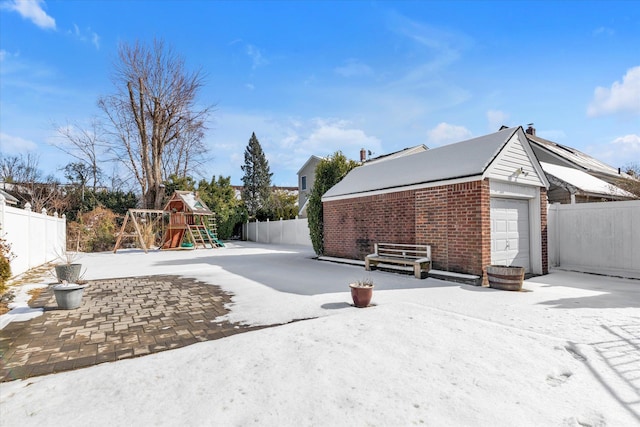 view of yard featuring a playground, a garage, and an outbuilding