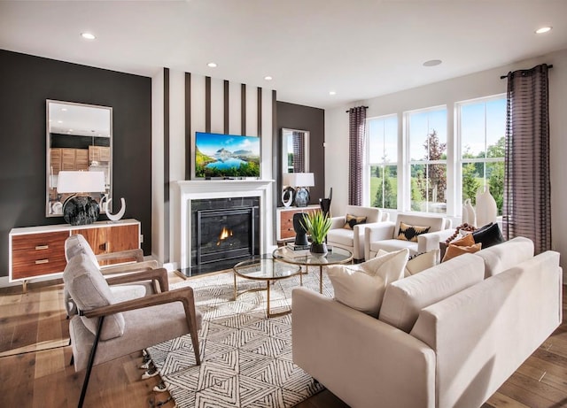 living area with a high end fireplace, recessed lighting, and wood finished floors