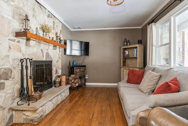 living room with crown molding, a fireplace, and wood-type flooring