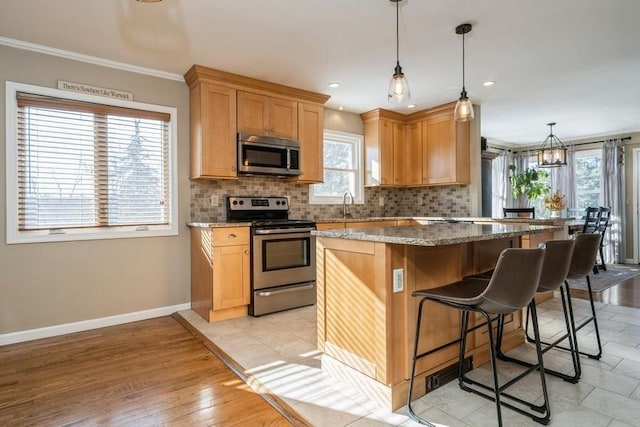 kitchen with stainless steel appliances, tasteful backsplash, a kitchen island, and stone counters